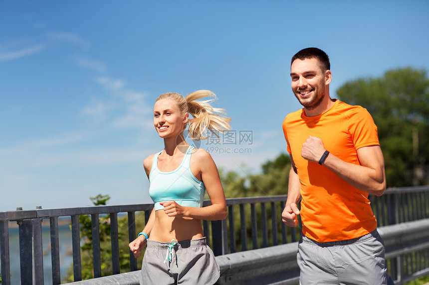 运动,技术生活方式的快乐的夫妇与健身跟踪者夏天沿着桥跑夫妇与健身跟踪者沿着桥跑图片