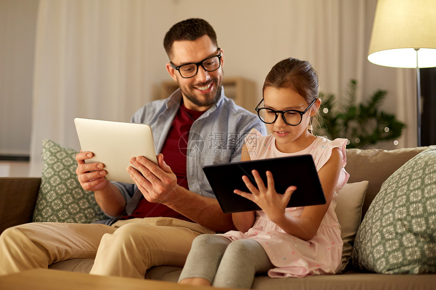 家庭,父亲技术快乐的父亲女儿戴着眼镜,晚上家用平板电脑父亲女儿家用平板电脑图片
