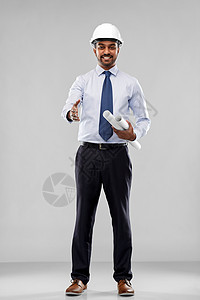 建筑,建筑业务建筑微笑的印度建筑师商人戴着蓝图,伸出手灰色背景上握手带头盔的建筑师握手背景图片