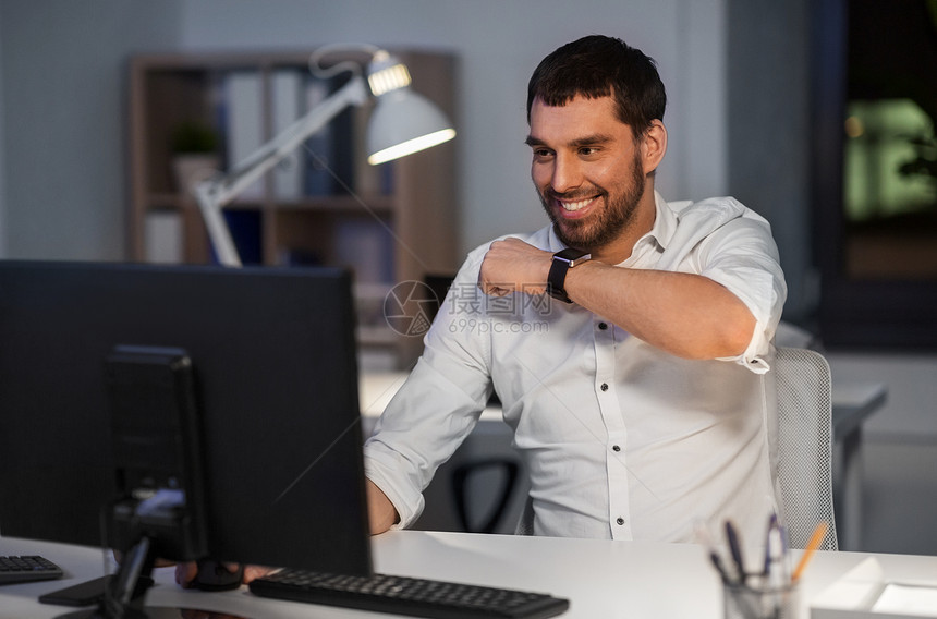 商业,技术时间管理快乐的商人用语音命令记录器智能手表夜间办公室智能手表上用语音命令的商人图片