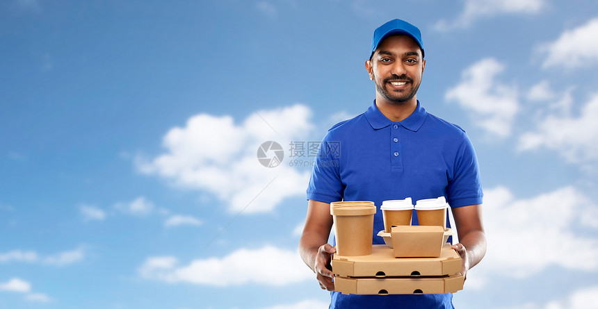 服务人的快乐的印度送货人与食物饮料的蓝色制服天空云的背景快乐的印度送货人带着食物饮料图片