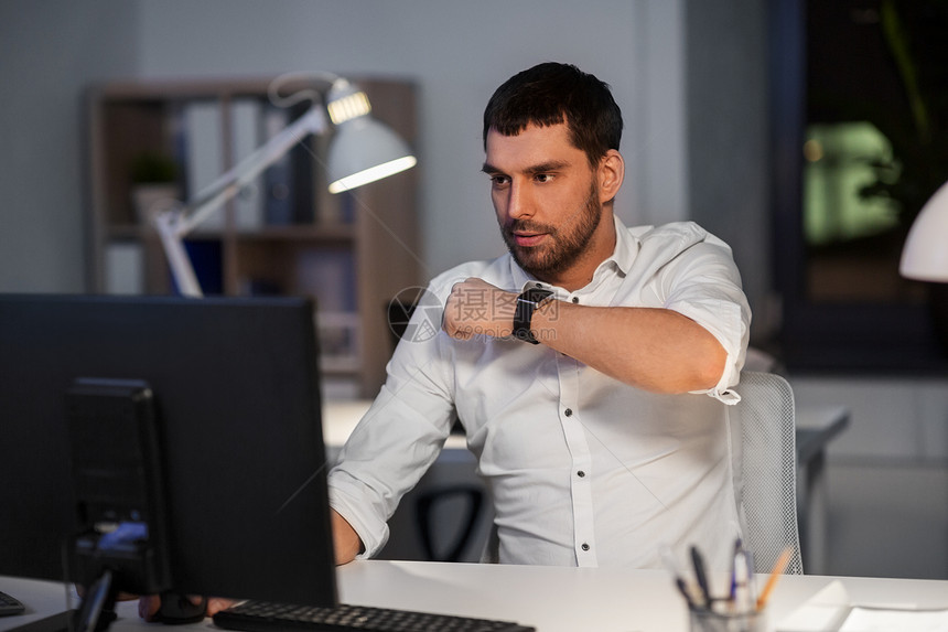商业,技术时间管理商人用语音命令记录器智能手表夜间办公室智能手表上用语音命令的商人图片