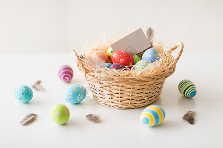 复活节,假日象彩色鸡蛋与贺卡柳条篮子白色背景复活节鸡蛋贺卡篮子里图片