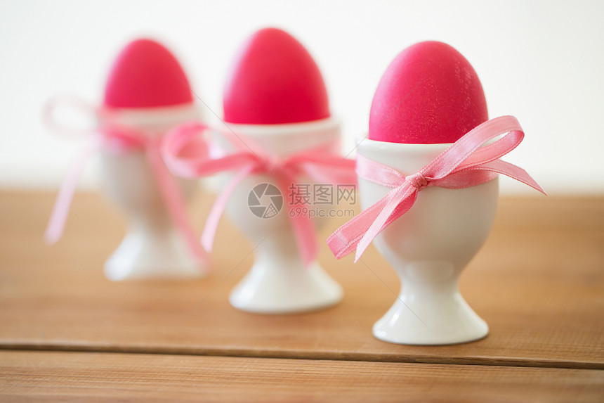 复活节假日粉红色鸡蛋陶瓷杯持人与丝带桌子上粉红色复活节彩蛋桌子上的持人图片