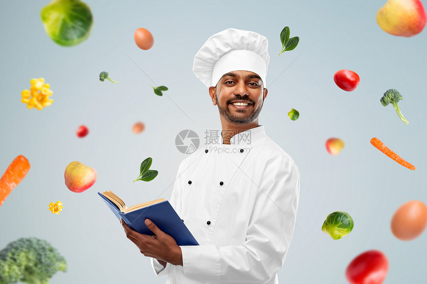 烹饪,专业健康的饮食快乐的男印度厨师与食谱蓝色背景蔬菜快乐的印度厨师用食谱代替蔬菜图片