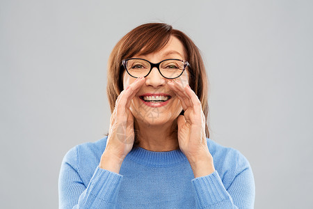 微笑的老年女性表示扩音的手势图片