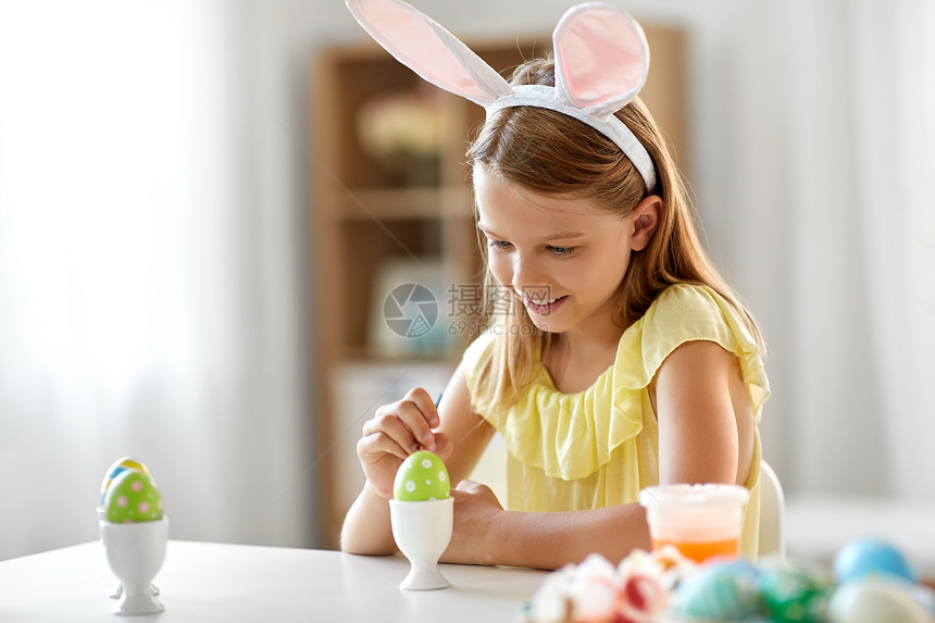 复活节,假日人们的快乐的女孩着色鸡蛋与颜色刷子家里快乐的女孩家里给复活节彩蛋着色图片