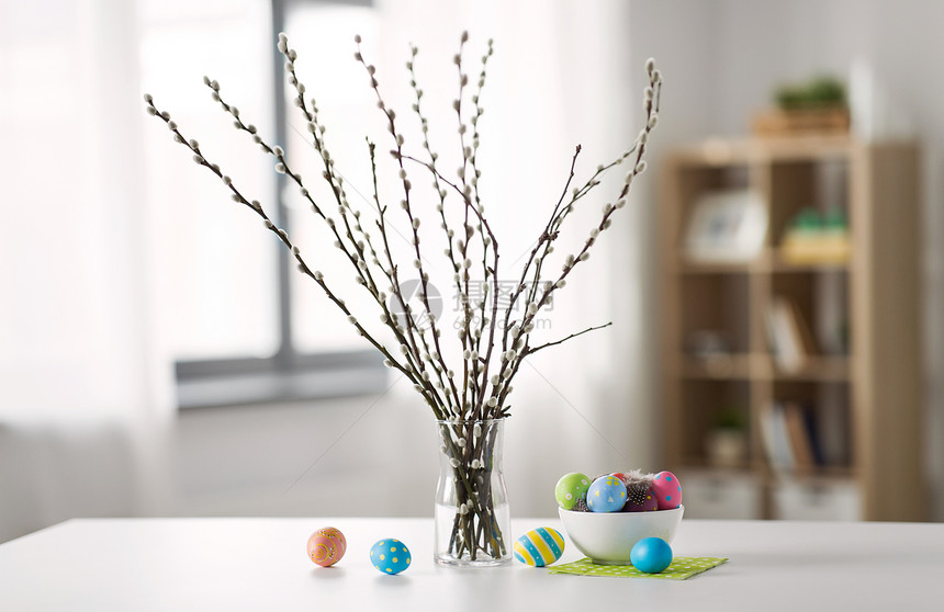 桌子上银柳枝彩色复活节彩蛋图片