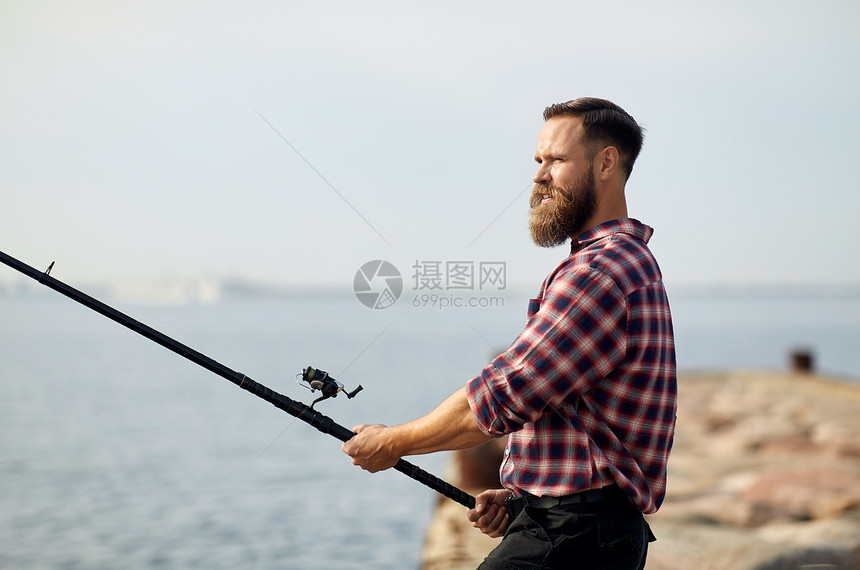 休闲人们的留着胡须的渔夫海上码头上钓鱼长胡子的渔夫,海上的码头上鱼竿图片