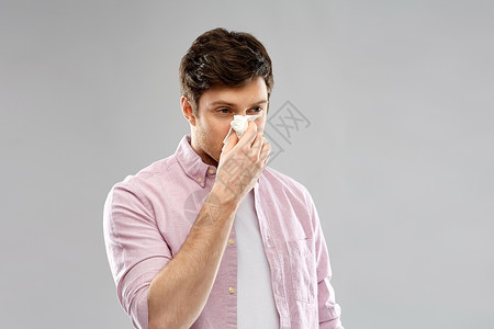 健康,鼻炎,感冒过敏的健康的人用纸巾鼻子灰色的背景上健康的人用纸巾鼻子图片
