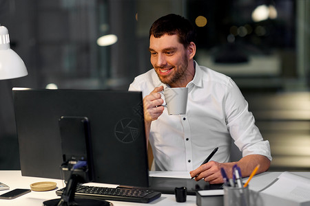 咖啡灯片商业,平技术创意男子师与电脑笔片饮用咖啡暗夜办公室办公室电脑钢笔平板电脑的师背景