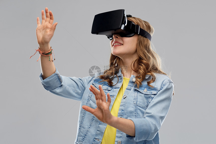 技术,增强现实,娱乐活动人的十几岁的女孩虚拟耳机VR眼镜灰色背景虚拟现实耳机VR眼镜中的少女图片