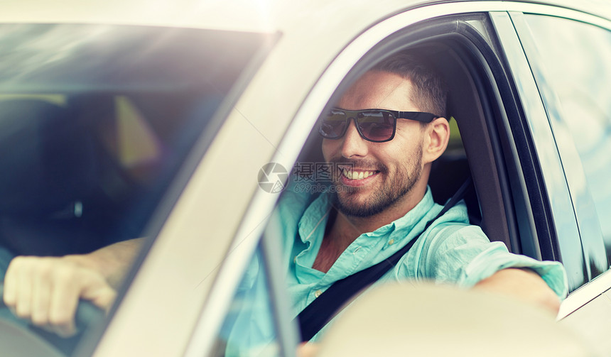 公路旅行,交通,旅行人的快乐的微笑男人戴着太阳镜驾驶汽车戴太阳镜开车的快乐微笑的人图片