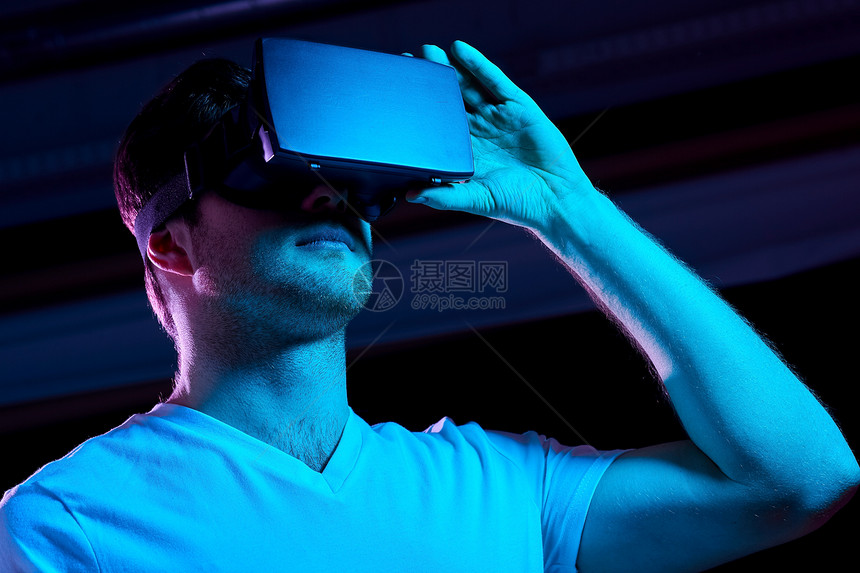 三维技术,虚拟现实,娱乐活动人的轻人VR眼镜上玩游戏,紫外线霓虹灯黑暗的房间虚拟现实耳机VR眼镜中的男人图片