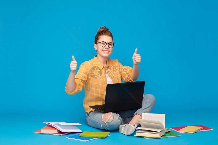 教育,高中,技术人的红头发的十几岁的学生女孩穿着格子衬衫撕裂的牛仔裤与书籍笔记本电脑拇指明亮的蓝色背景十几图片