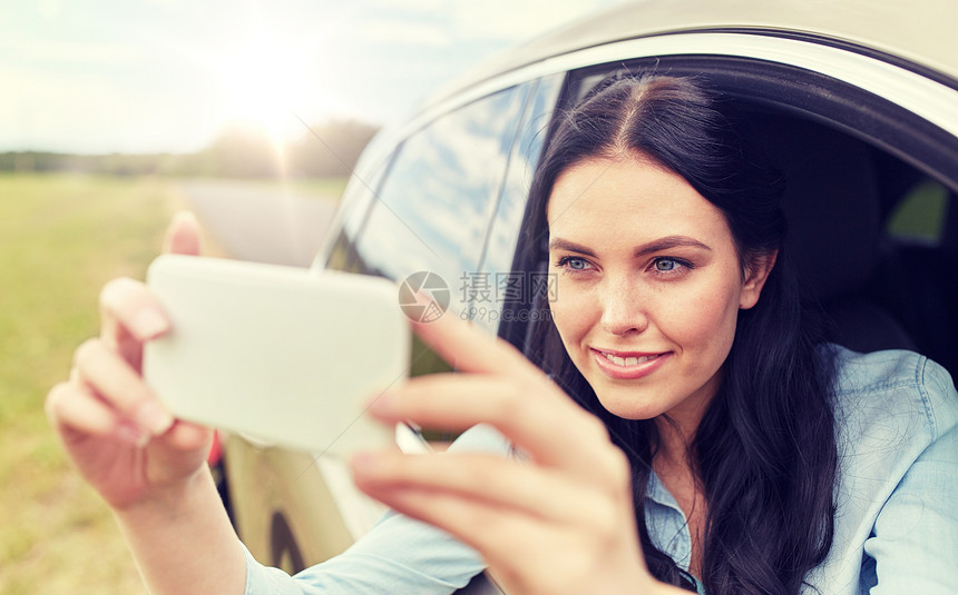 暑假,旅行,公路旅行,技术人的快乐的轻女人开车,用智能手机自拍视频快乐的轻女人用智能手机开车图片