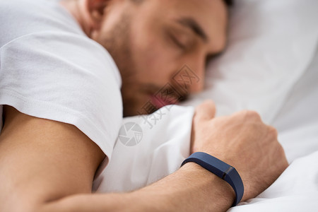 人,技术休息的与活动跟踪者睡床上与活动跟踪器睡觉的人图片