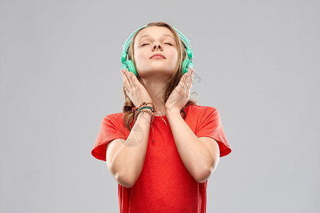 音乐,技术人的快乐的少女耳机红色T恤灰色背景带耳机的快乐少女图片