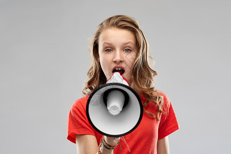女权利女权主义别平等穿着红色T恤的愤怒少女灰色背景下扩音器说话愤怒的十几岁的女孩扩音器说话背景图片