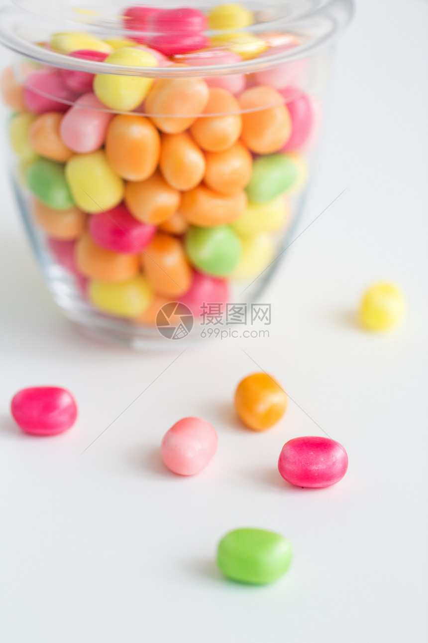 食物,糖果糖果的璃瓶与彩色糖果滴白色背景用五颜六色的糖果滴璃瓶图片