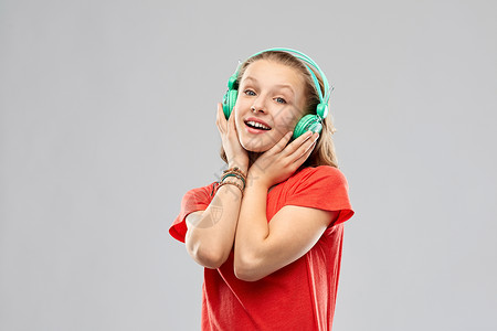 音乐,技术人的快乐的少女耳机红色T恤灰色背景带耳机的快乐少女图片