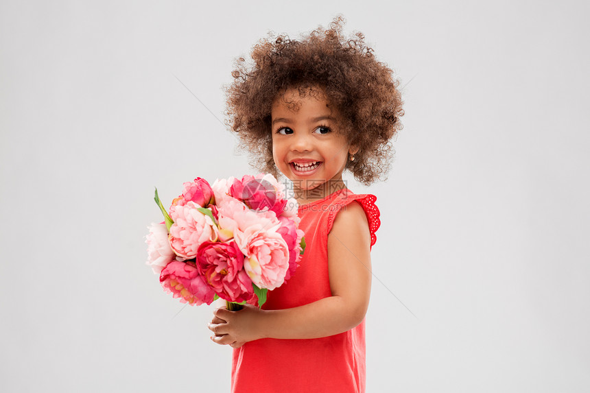 童人的快乐的非裔美国女孩与花灰色背景快乐的非裔美国女孩带着花图片
