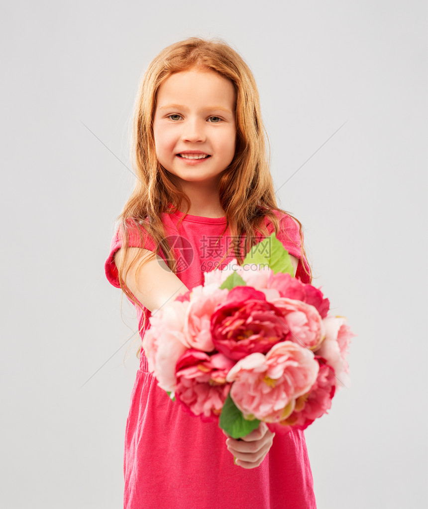 童人的快乐的红头发女孩与花灰色背景快乐的红头发女孩带着花图片