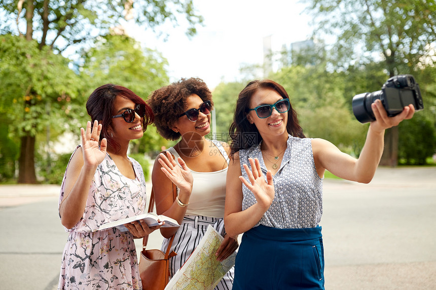 旅游,旅游技术快乐的女与城市指南记录视频博客夏季公园相机挥手旅行录制视频博客的女图片