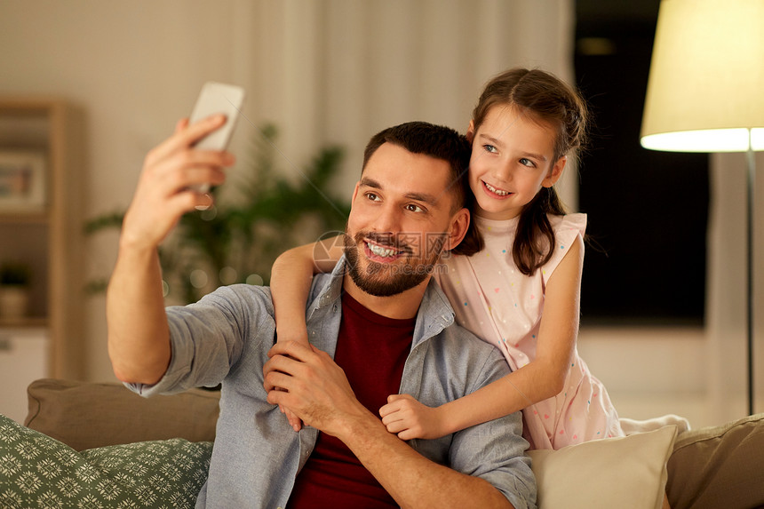 人们,家庭技术快乐的父亲小女儿家里用智能手机自拍父亲女儿家自拍图片