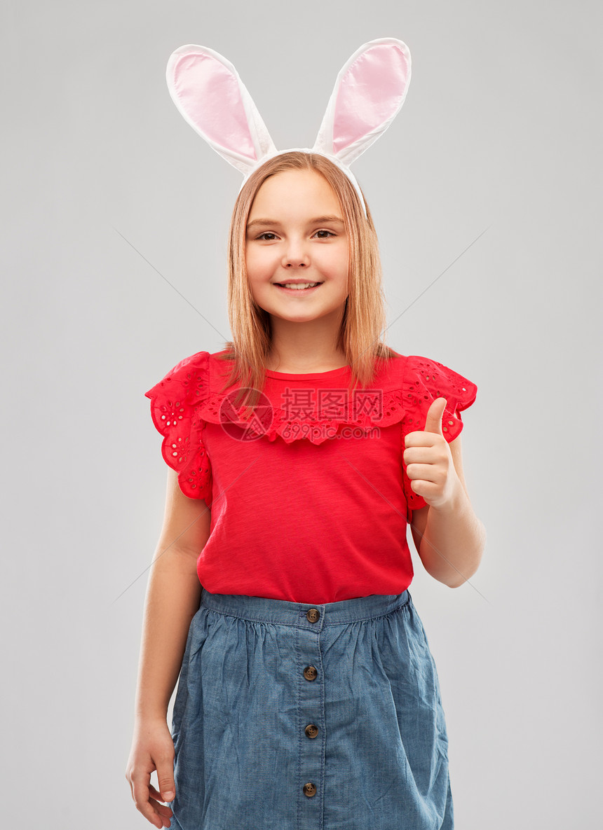 复活节,假期童的快乐的女孩戴着兔子耳朵头巾,灰色背景上竖大拇指戴复活节兔子耳朵的女孩竖大拇指图片