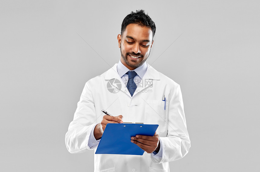 医学,科学职业微笑的印度男医生科学家穿白色外套,剪贴板灰色背景微笑的印度医生科学家与剪贴板图片