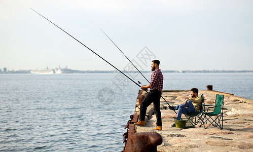 休闲人们的快乐的朋友与钓鱼竿码头海上码头上钓竿的快乐朋友背景图片