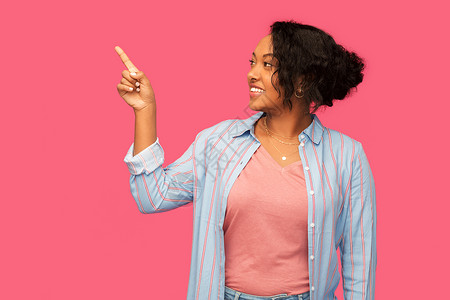 人手势快乐的非裔美国轻女人指着粉红色的背景快乐的非裔美国妇女指指点点图片