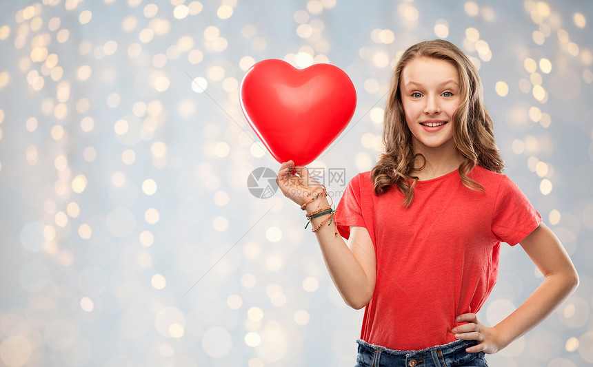 情人节,爱人的微笑美丽的十几岁女孩,长发红色T恤,着心形气球节日的灯光背景带着红色心形气球的微笑少女图片
