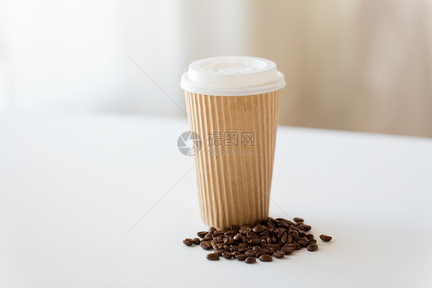 外卖饮料的纸杯烤咖啡豆白色桌子上把杯子烤咖啡豆放桌子上图片