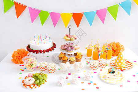 生日蛋糕卡派节日生日蛋糕与蜡烛草莓,花环,饮料食物桌子上生日聚会上桌子上的食物饮料背景