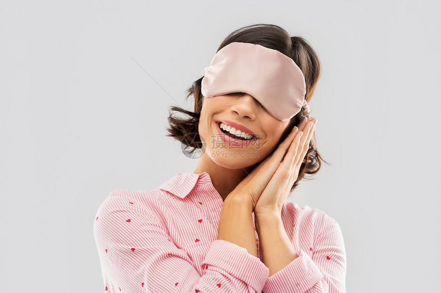 人们睡觉时间的快乐的轻女人睡衣眼睛具灰色的背景快乐的轻女人穿着睡衣眼罩图片