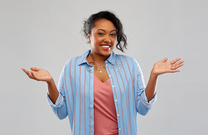人,手势情感的愚蠢的非裔美国轻妇女耸耸肩灰色的背景无知的非裔美国妇女耸耸肩图片