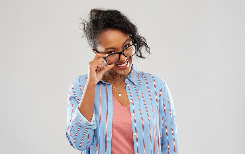 教育,视觉人的快乐的微笑非裔美国妇女戴着灰色背景的眼镜戴眼镜的快乐微笑的非裔美国妇女图片
