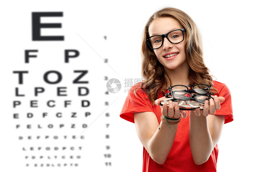视觉,视力眼镜微笑的十几岁的学生女孩着堆眼镜眼睛测试图表背景十几岁的女孩着眼镜眼睛测试图表上图片