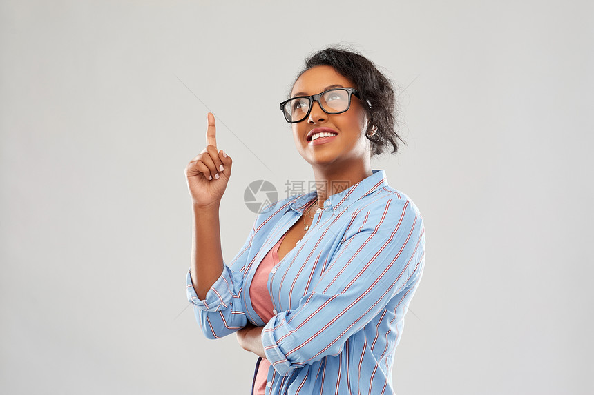 教育,想法人的快乐的微笑非裔美国学生妇女戴着眼镜,手指灰色的背景上戴眼镜的非洲学生妇女手指向上图片
