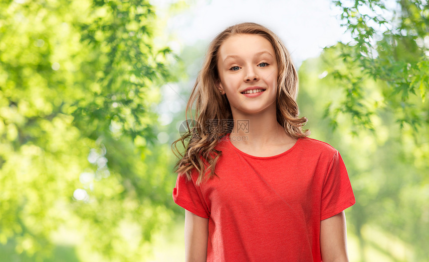 人们的微笑的十几岁女孩,长发红色T恤上绿色的自然背景微笑的少女自然背景图片