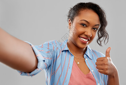 人手势快乐的非裔美国轻妇女自拍拇指灰色背景快乐的非裔美国妇女自拍图片