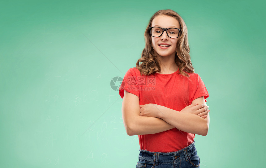 教育,学校人的微笑的十几岁的学生女孩戴着眼镜红色T恤,交叉手臂绿色粉笔板背景上微笑的学生女孩戴着绿色的眼镜图片