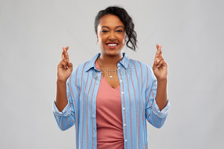 人,手势肖像快乐的非裔美国轻妇女,手指交叉灰色背景上非裔美国妇女手指交叉图片