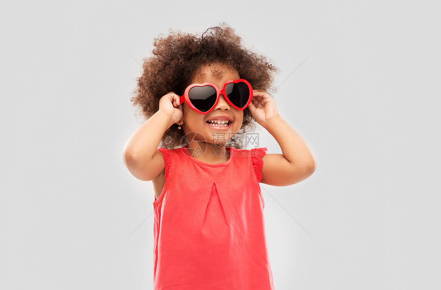 童,情人节夏天的快乐的非裔美国女孩灰色背景的心形太阳镜非洲阿米卡女孩戴着心形太阳镜图片