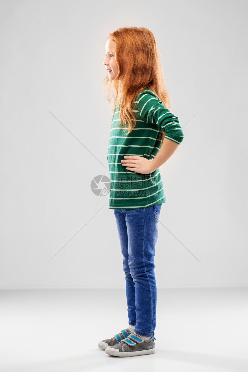 童,时尚人的微笑的红色头发女孩摆绿色条纹衬衫牛仔裤灰色背景微笑的红头发女孩摆着条纹衬衫图片