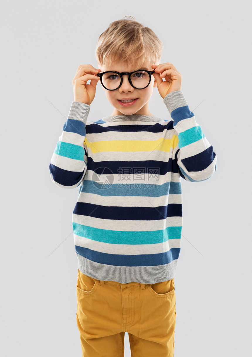 学校,教育视觉微笑的小男孩穿条纹套头衫灰色背景的眼镜的肖像戴眼镜条纹套衫的微笑男孩图片