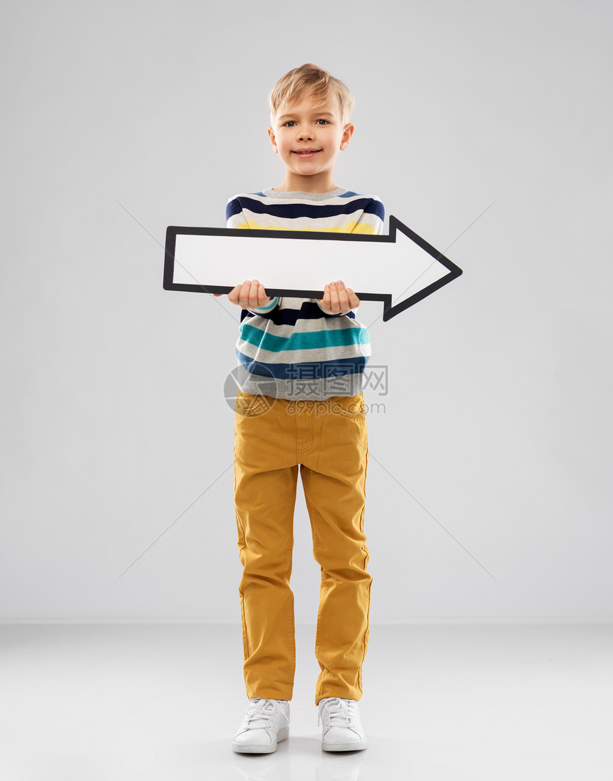 方向,童人的漂亮的小男孩条纹套头衫的肖像,着白色的大,向右的厚厚的箭头灰色的背景上男孩着大的白色向右的厚箭图片
