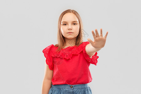 责难童,禁止拒绝美丽的女孩穿着红色衬衫裙子,灰色背景上停止手势漂亮的女孩表现出停止的姿态背景